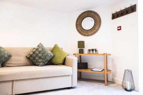 a living room with a couch and a mirror at Hereford Central Apartment in Hereford