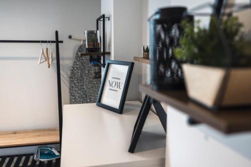 a stand with a sign on a table with plants at Hereford Central Apartment in Hereford
