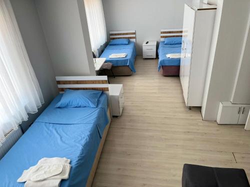 two beds in a room with blue sheets at BULUT GAYE Pansiyon in Edirne