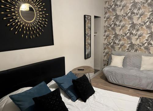 a bedroom with a bed and a couch and a mirror at Gite des Coteaux Pmr in Sainte-Maure-de-Touraine