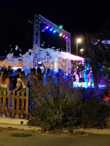 a group of people standing behind a fence at night at Mobil home en Provence - Camping 4 étoiles- 2 chambres -4 à 6 pers-clim-terrasse-TV in Cadenet
