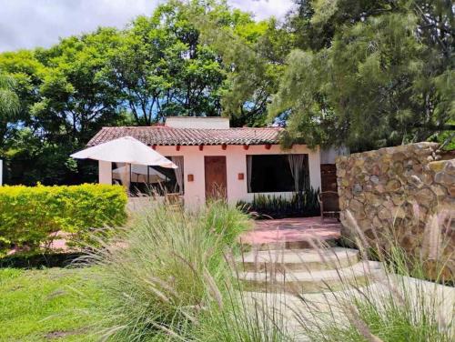 a small house with an umbrella in a yard at Paraje Real Malinalco in San Martín