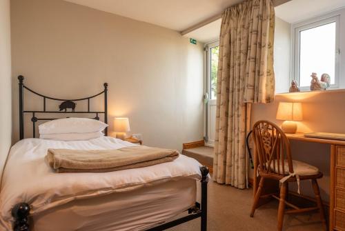 a bedroom with a bed and a desk and a chair at Rye Hill Farm in Hexham