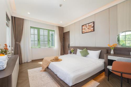 a bedroom with a large white bed and a desk at La isla Apartments & Villas - Sea View & Fireworks Phu Quoc in Phu Quoc