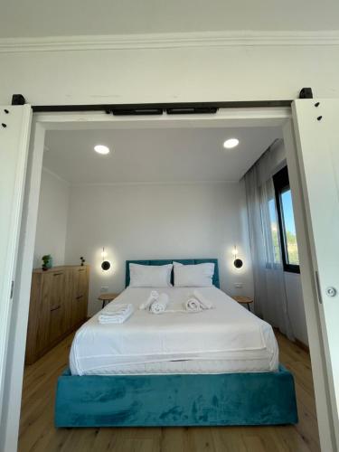 a bedroom with a large bed with two towels on it at Azzurro Boutique Apartaments in Sarandë