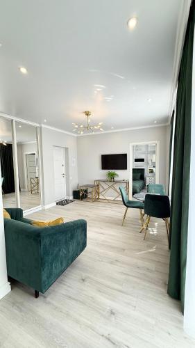 a living room with a couch and a table at Luxury Emerald Apartments in Irpin'