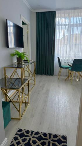 a living room with a television and a table and chairs at Luxury Emerald Apartments in Irpin'
