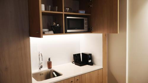 a kitchen with a sink and a microwave at Holiday Inn Express & Suites Lisbon - Príncipe Real by IHG in Lisbon