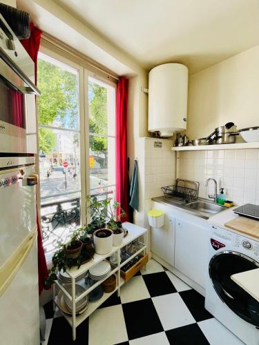 - une cuisine avec un sol en damier noir et blanc dans l'établissement Best flat in Paris, à Paris