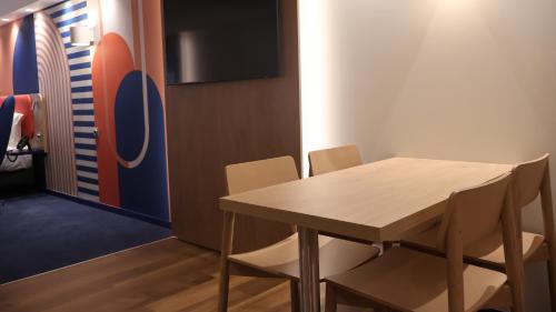 a dining room with a table and chairs and a surfboard at Holiday Inn Express & Suites Lisbon - Príncipe Real by IHG in Lisbon