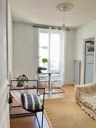 un salon avec une table et une fenêtre dans l'établissement Best flat in Paris, à Paris
