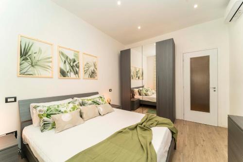 Un dormitorio con una gran cama blanca con almohadas verdes. en Appartamento Green House, en Turín