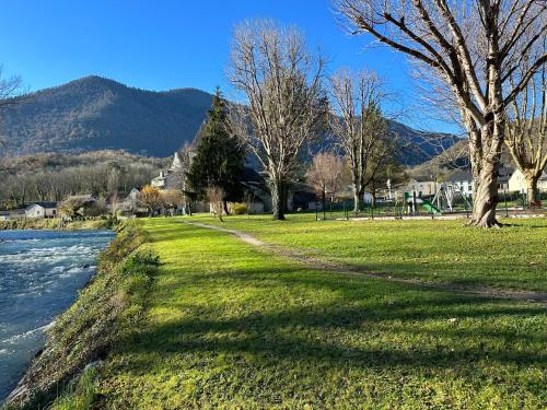 a park next to a river with mountains in the background at Studio Cosy en vallée d'Ossau in Izest
