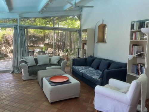 un salon avec un canapé bleu et des chaises dans l'établissement Agréable maison de 65 m2 avec grande piscine, à Aix-en-Provence