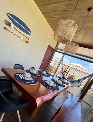 a dining room table with chairs and a large window at Casa BoxHome em Santo Amaro-MA in Santo Amaro