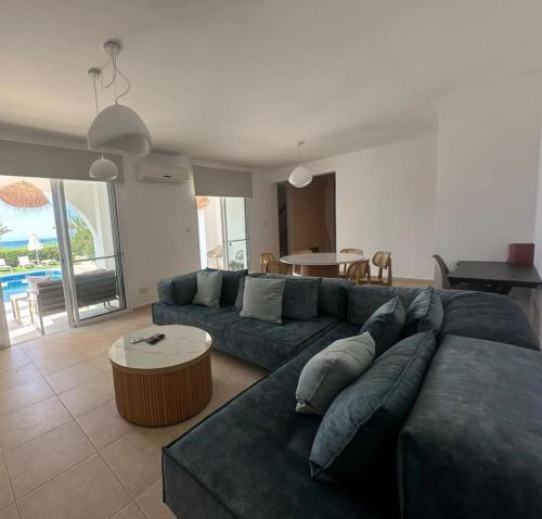 a living room with a blue couch and a table at LATCHI RIVIERA THALASSA Villa in Neo Chorio