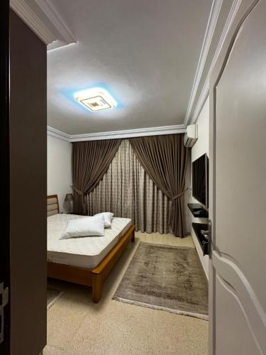 ein kleines Schlafzimmer mit einem Bett und einem Fenster in der Unterkunft Kantoui apartment in Kasnadar