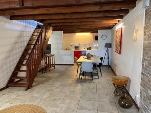 a room with a staircase and a table and a kitchen at DILL49 in Fort-de-France