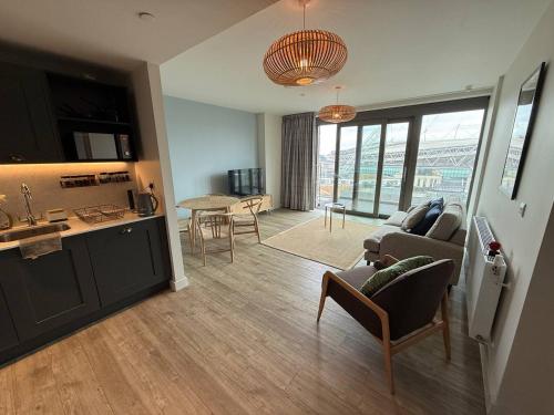 a kitchen and living room with a couch and a table at Wembley Stadium Modern 1 Bed Apartment With Amazing Views in London