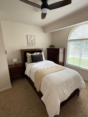 a bedroom with a large bed with a ceiling fan at Lovely Provo Oasis in Provo