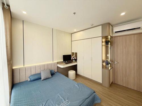 a bedroom with a bed and a desk and a television at Luxhomes TC1 Canopy Smart City in Phú Thú