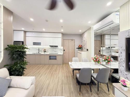 a kitchen and living room with a table and chairs at TC1 Canopy Luxhome Smart City in Phú Thú