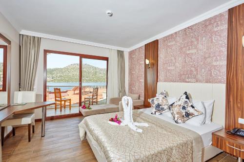 a hotel room with a bed and a view of the ocean at Tymnos Hotel in Bozburun