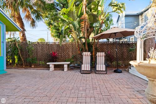 a patio with a bench and an umbrella and a fence at The Love Shacks in Lake Worth