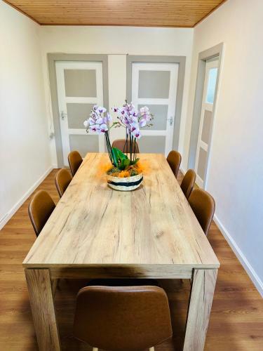 a wooden table with flowers on it in a room at La Petite Maline friends & family in Sierre