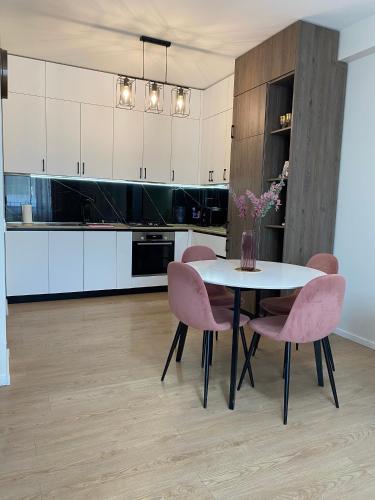 Cozy Apartment For Daily Rent في تبليسي: مطبخ مع طاولة وبعض الكراسي الزهرية