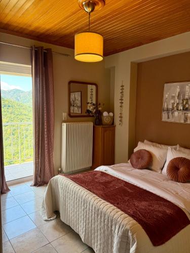 a bedroom with a large bed with a large window at Arcadian Escape - Tsiaxtai Group in Lagadia