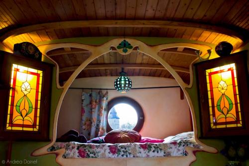 Cama en habitación con vidrieras en B&B Le Manoir d'Ange, en Ferrières