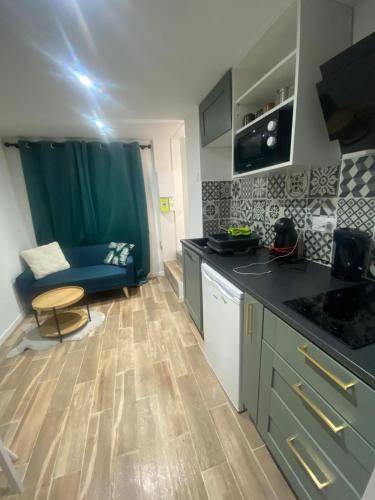 Appartement - Angers في أنجيه: مطبخ ذو أسطح عمل سوداء وأريكة زرقاء