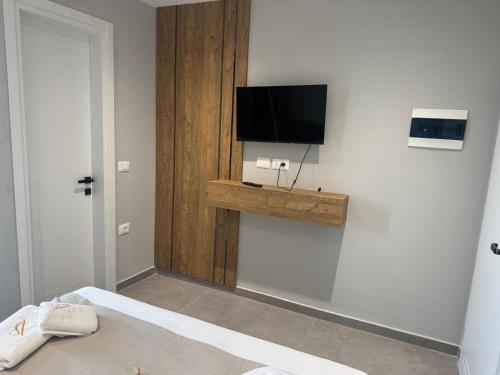 a bedroom with a flat screen tv on a wall at Hotel Sisana in Vlorë