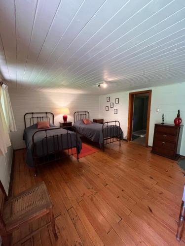 a room with two beds and a wooden floor at Alma Sur Lodge in Chillancito