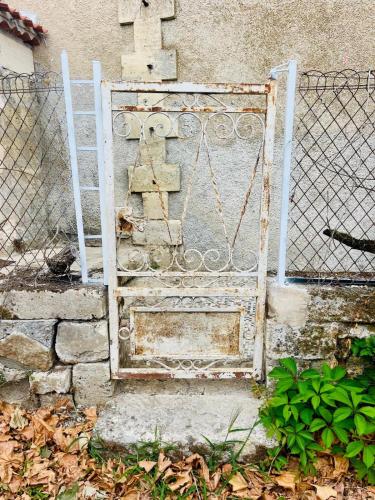 an old gate with a cross on a fence at Petit Chai au coeur de village in Saint-Christophe-des-Bardes