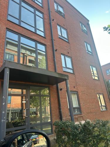 a side view mirror of a red brick building at Lovely 1 bedroom top floor flat at Chocolate Quarter near city of Bath in Keynsham