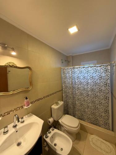 a bathroom with a toilet and a sink and a shower at Las Margaritas in Pila