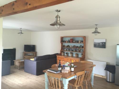 un soggiorno con un tavolo e un divano di Tigh a Chaolais, Bosta House, Isle of Lewis 