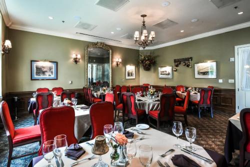 a dining room with tables and red chairs at River Inn of Harbor Town in Memphis