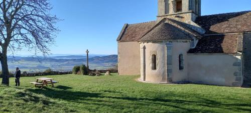 a man standing next to a picnic table next to a church at La belle étape in Montmélas-Saint-Sorlin