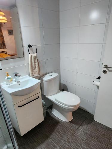 a white bathroom with a toilet and a sink at Larnaca Breeze in Pyla