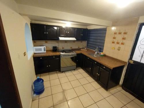 a small kitchen with a stove and a microwave at Depa Colima in Ciudad Obregón