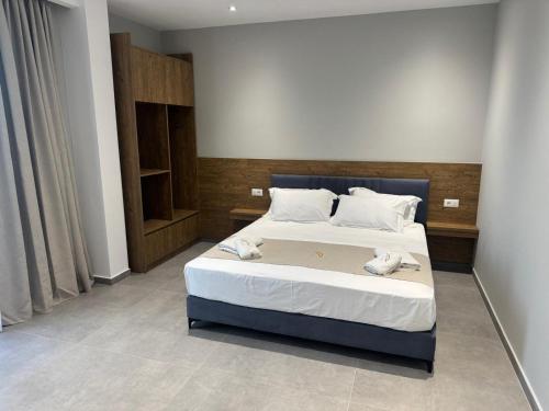 a bedroom with a bed with two towels on it at Hotel Sisana in Vlorë