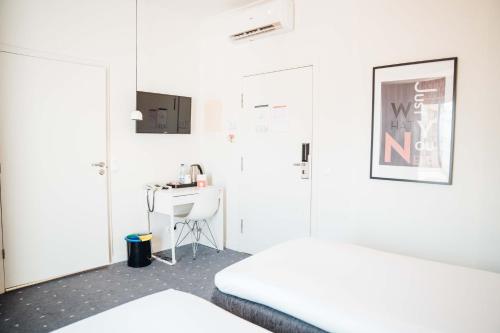 a white room with a desk and a bed at Stay Hotel Faro Centro in Faro
