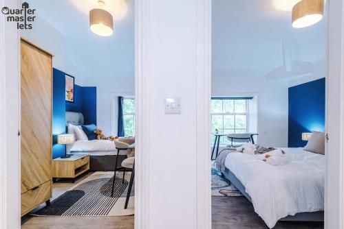 a bedroom with blue walls and two beds at 2 Bedroom Top Floor Apartment that Sleeps 4 in Birkenhead