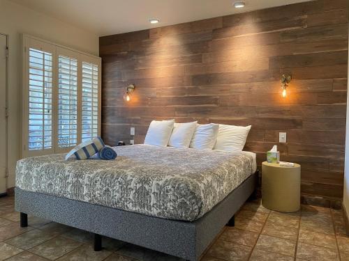 a bedroom with a large bed with a wooden wall at Desert Paradise - A Men's Clothing Optional Resort in Palm Springs