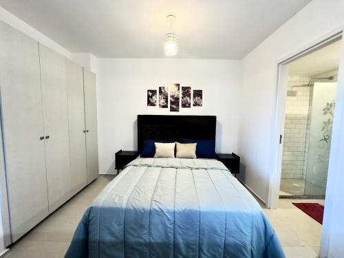 a bedroom with a blue bed in a white room at Apartamento en Luque cerca de Asunción 219 in Luque