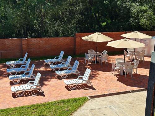 a group of chairs and tables and umbrellas at Apartamento en Luque cerca de Asunción 219 in Luque