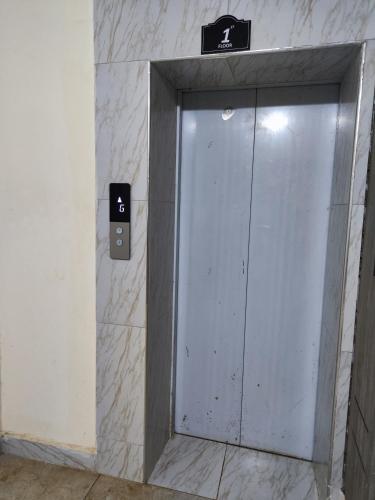 a glass door in a bathroom with a sign on a wall at Platinum Place in Kikuyu